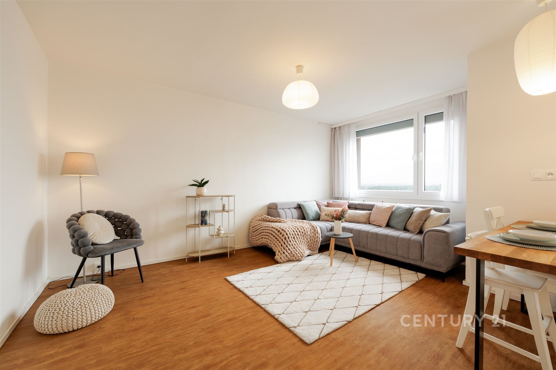 Světlý obývací pokoj s parketovou podlahou, velká okna, moderní nábytek a minimalistický design dodávají místnosti vzdušnost a pohodlí. Hana Yates realitní makléřka pro Prahu.