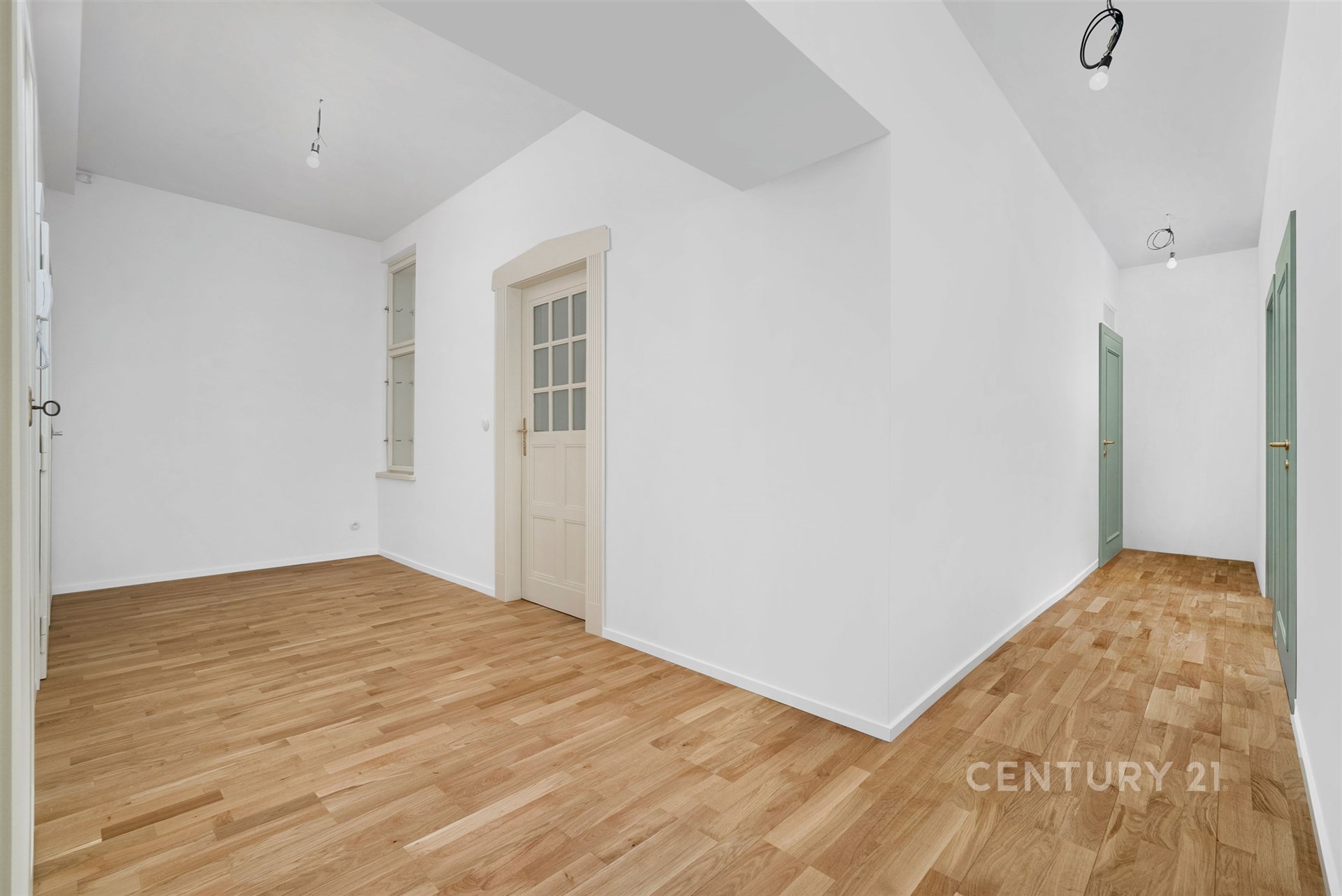 Prostorná chodba s parketovou podlahou, nově vymalované stěny, dřevěné dveře, moderní design interiéru.