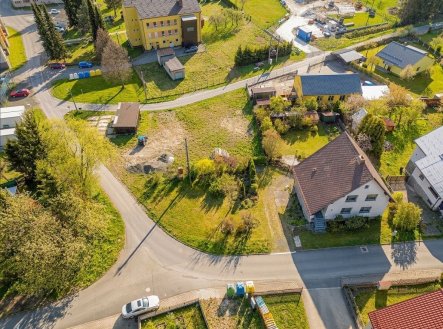 Letecký pohled na stavební pozemek v klidné části města s přístupovou cestou, vhodný pro výstavbu, obklopený zelení a rodinnými domy. | Prodej - dům/vila, 260 m²