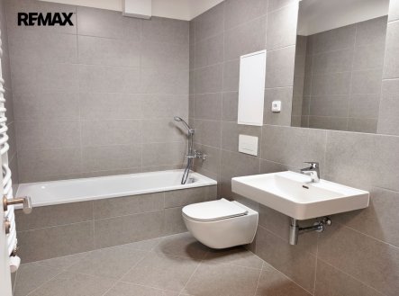 Koupelna s vanou, umyvadlem, toaletou a topným žebříkem. | Pronájem bytu, 2+kk, 50 m²