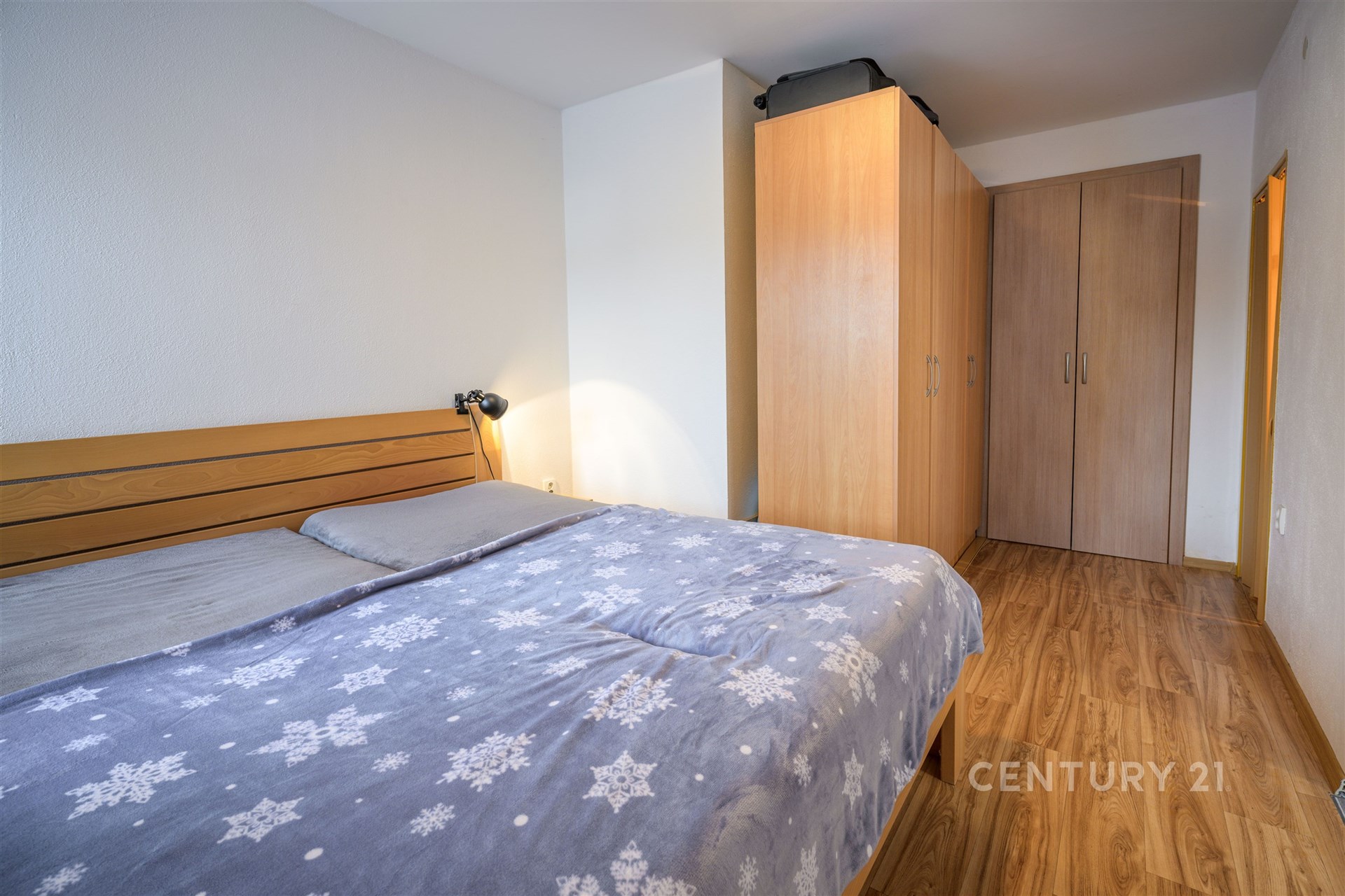 Prostorná ložnice s parketovou podlahou, vestavěná skříň a moderní design interiéru.
