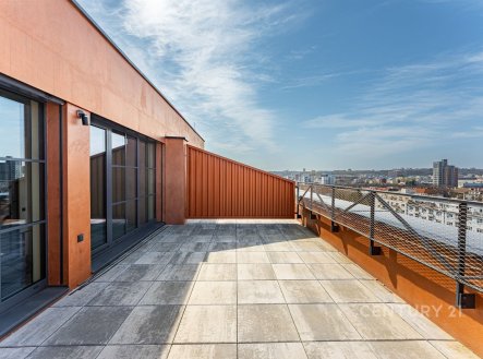 Prostorná terasa s dlažbou, moderní zábradlí a velká okna nabízejí panoramatický výhled na město. | Prodej bytu, 4+kk, 101 m²
