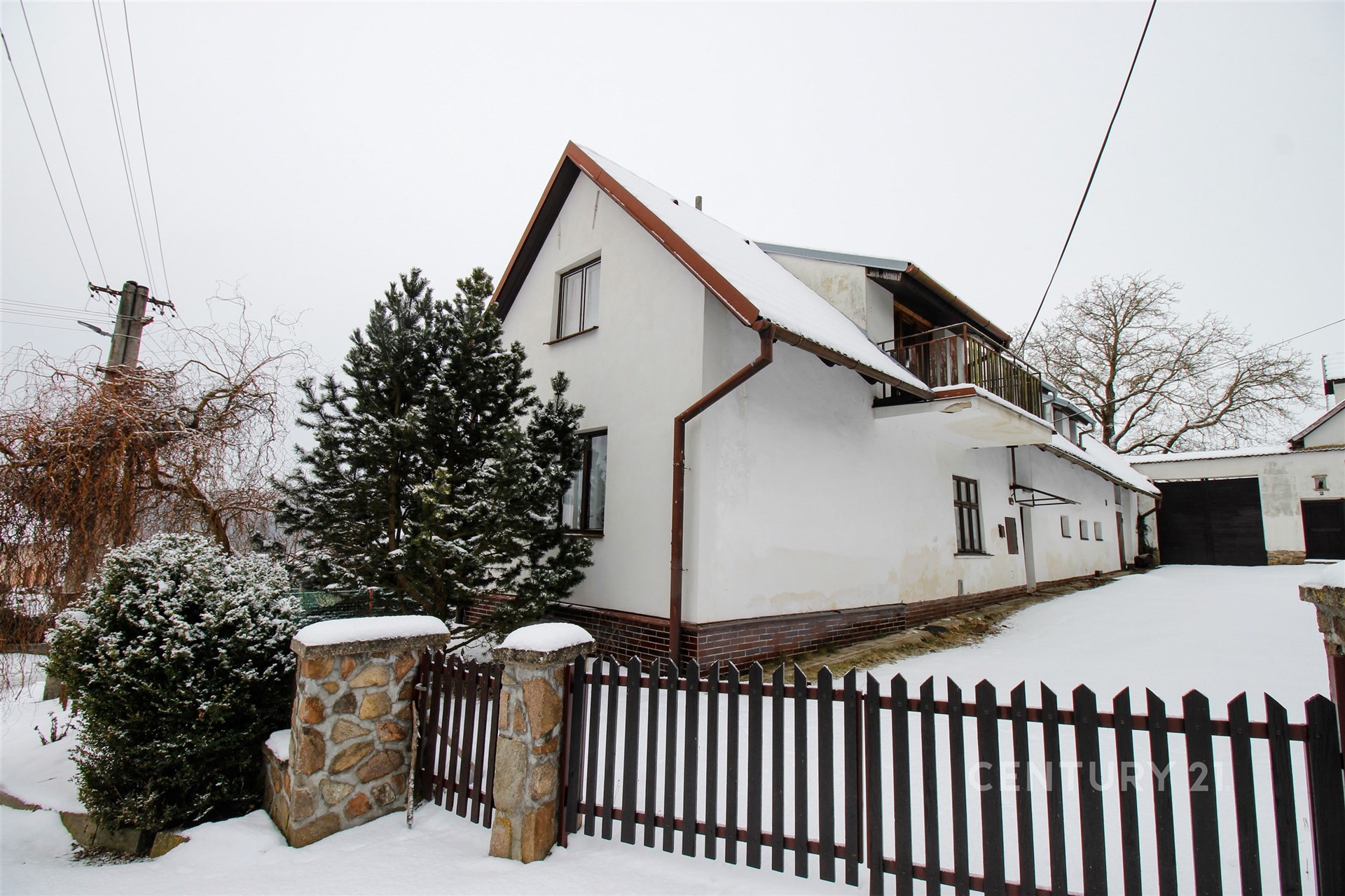 Dům s klasickou fasádou, sedlovou střechou a dřevěným plotem, zasněžená zahrada, klidná lokalita, ideální pro rodiny