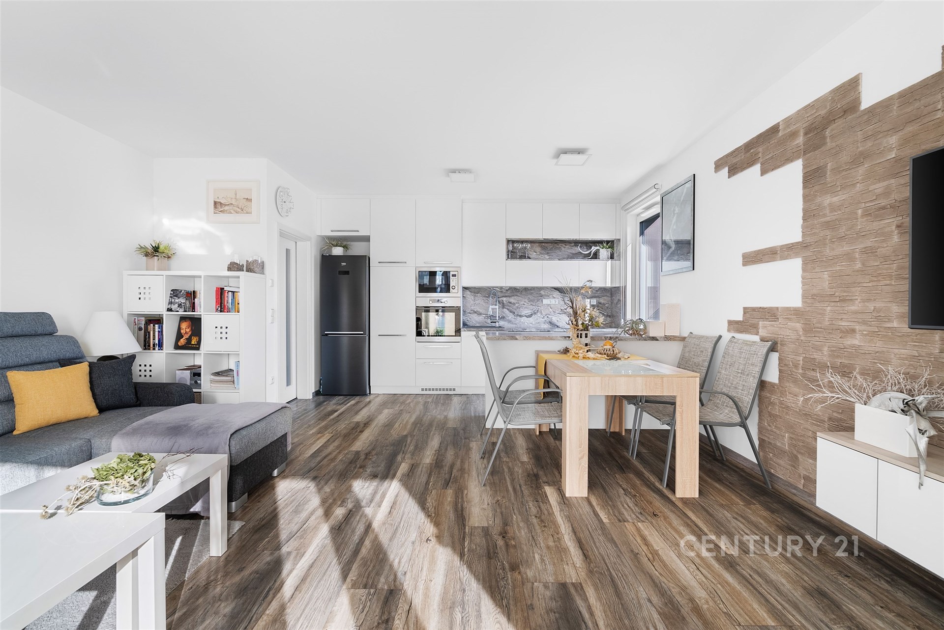 Světlý obývací pokoj spojený s moderní kuchyní, parketová podlaha, velká okna, světlý interiér, vestavěné skříně, stylový design.