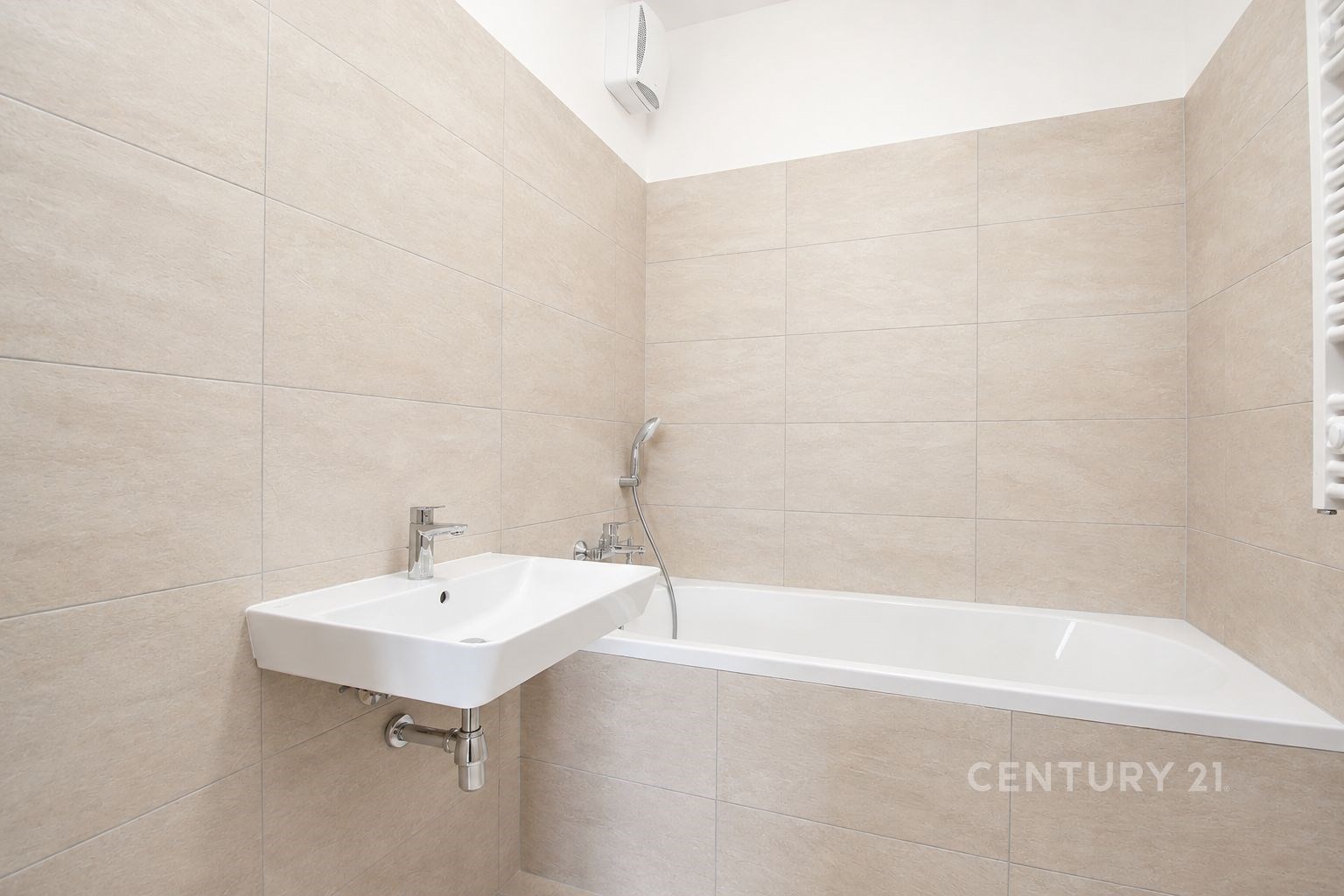 Moderní koupelna s dlažbou, vestavěnou vanou a umyvadlem, světlé neutrální odstíny pro elegantní vzhled