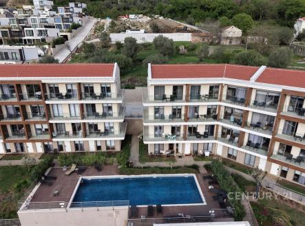 Moderní rezidenční komplex s venkovním bazénem, terasami a zelení, ideální pro luxusní bydlení. Kvalitní architektura a klidné okolí.