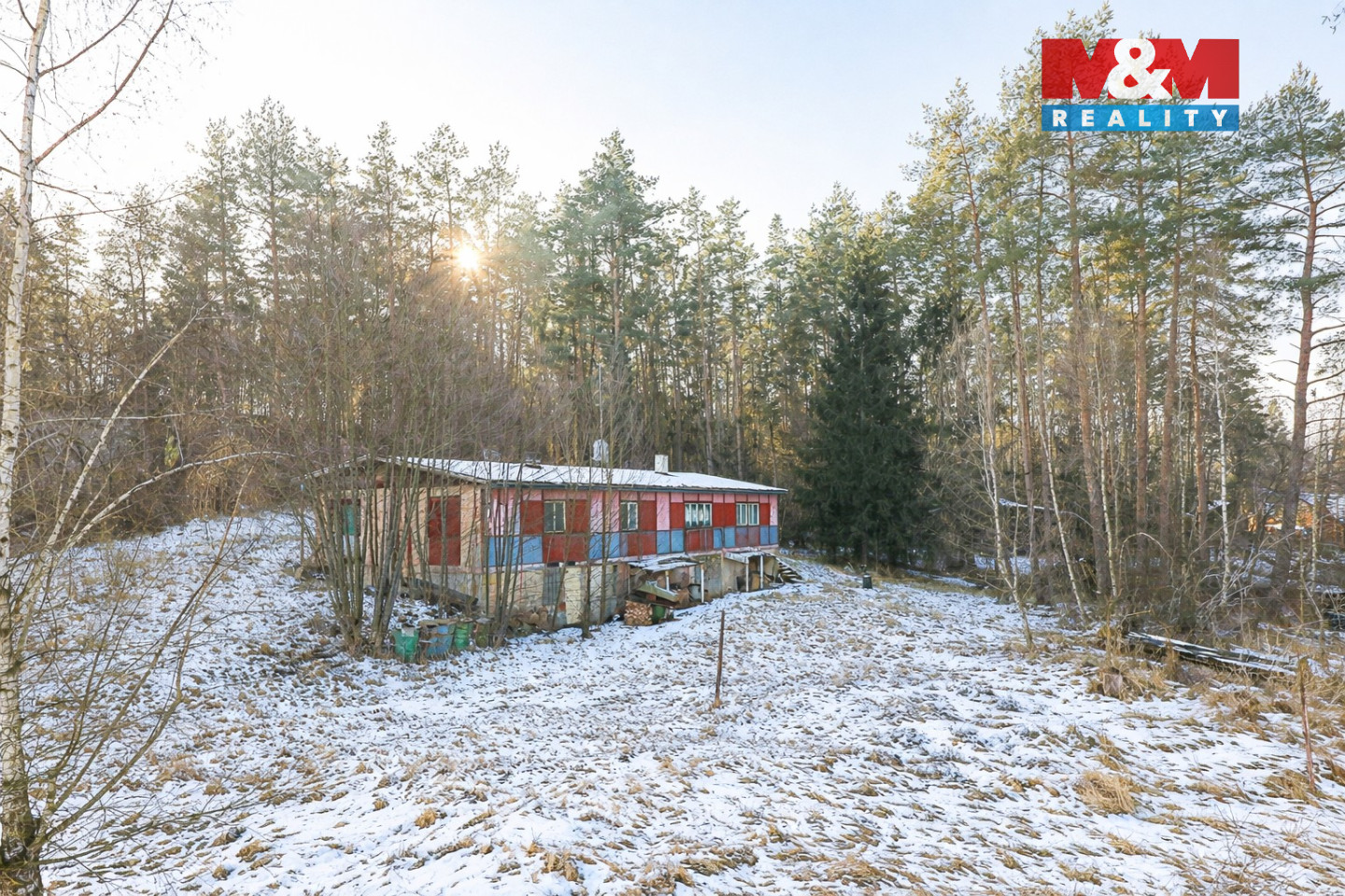 Sněhem pokrytá chata v lesích.jpg