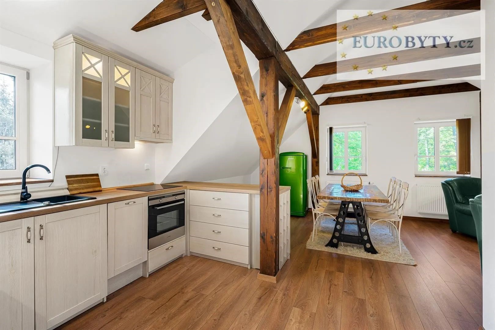 kuchyně s otevírá se do obývacího prostoru, dřevěná podlaha, trámový strop, a trouba
