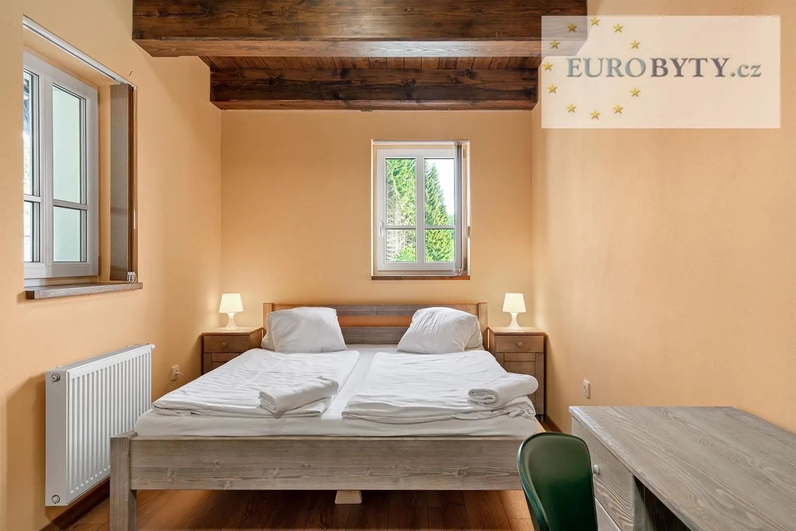 pokoj / ložnice s radiátor, trámový strop, dřevěná podlaha, a přirozené světlo