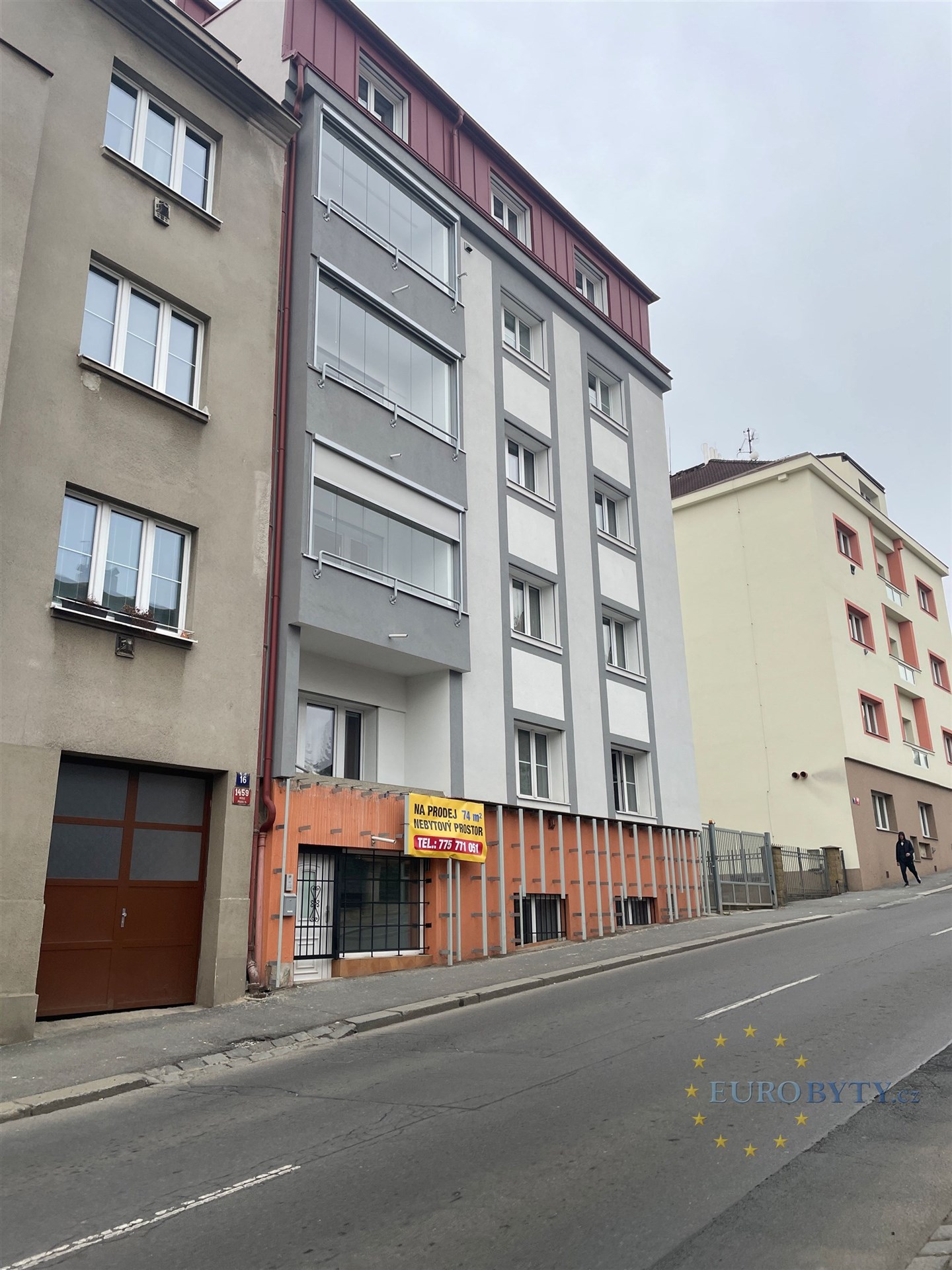 Fasáda bytového domu s moderní rekonstrukcí, nová okna a světlé omítky, udržovaný stav na klidné ulici poblíž centra města.