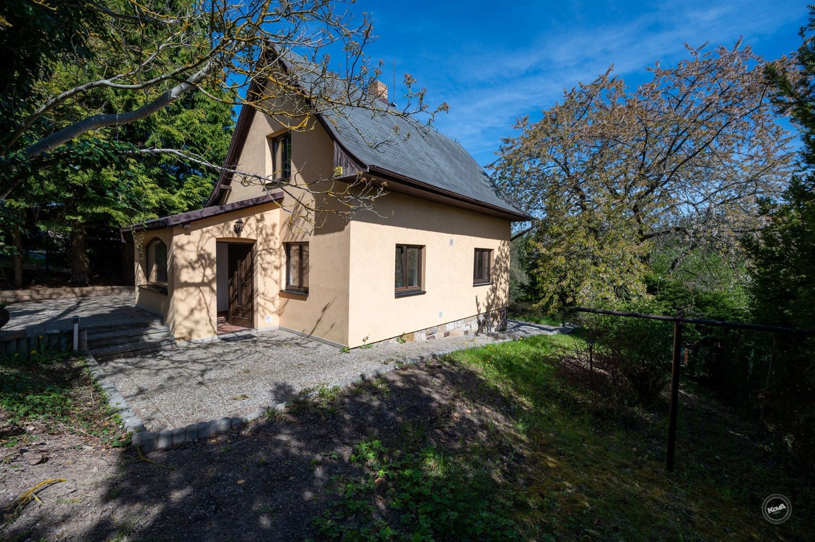 Rodinný dům s terasou, obklopený zelení, nabízí klidné prostředí. Přírodní prvky a klidná lokalita vynikají v exteriéru tohoto domu.