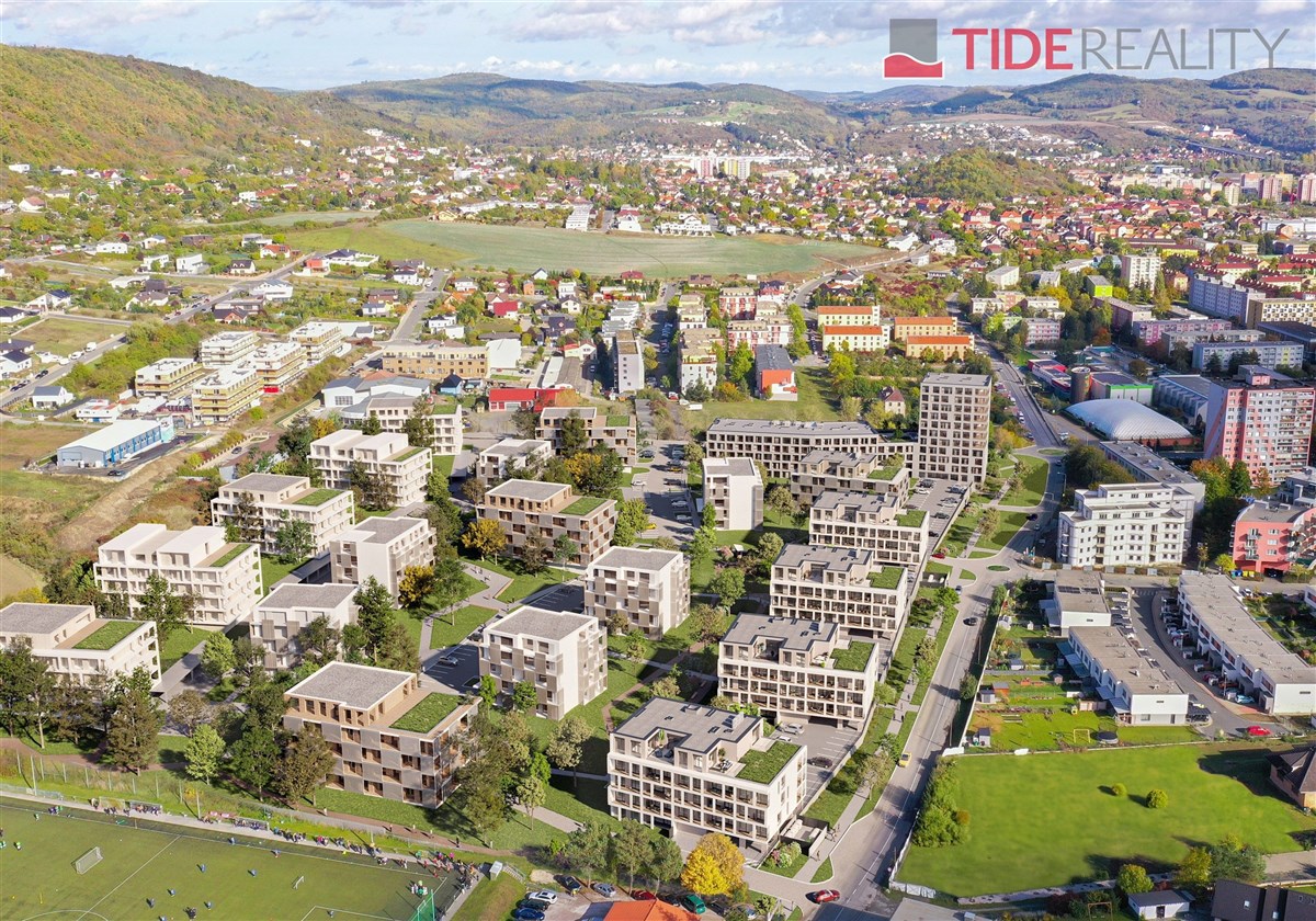 Nový bytový komplex obklopený zelení a moderní architekturou, nabízí prostorné byty s velkými okny a parketovými podlahami, ideální pro rodiny