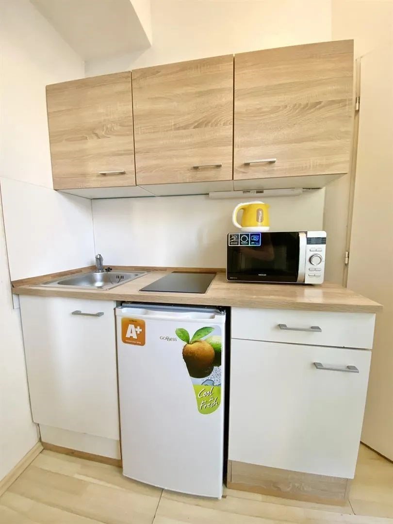 kuchyně s deformace, světle hnědé skříně, mikrovlnná trouba, a myčka