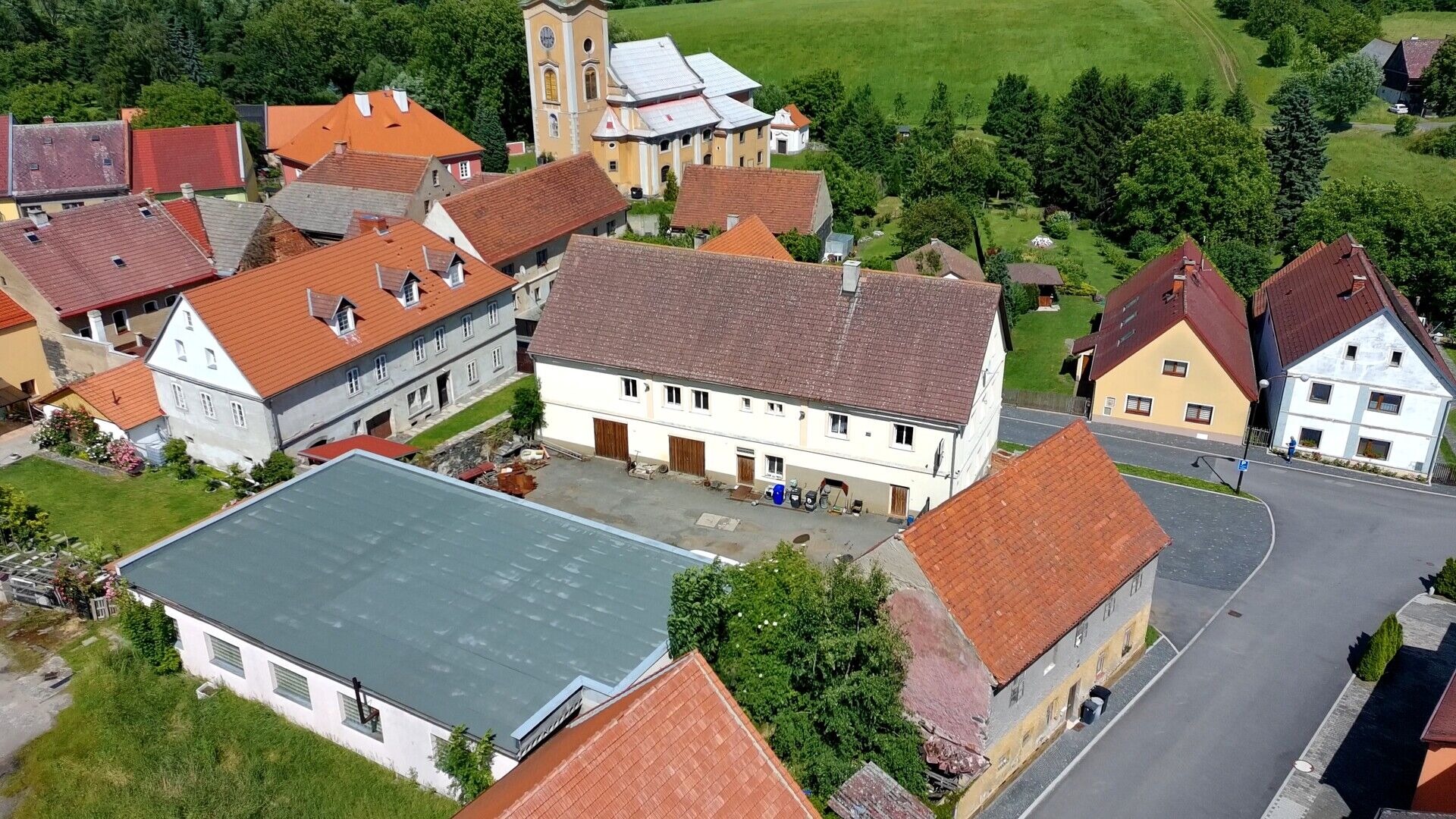 Areál pro podnikání zahrnující provozní budovu s byty, dílnami a sklady a budovu garáží-autodílen