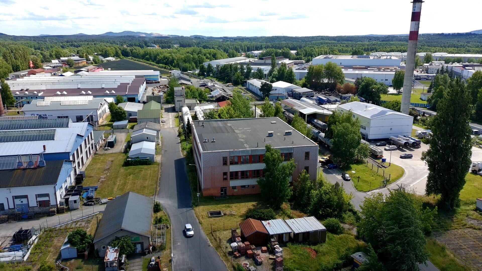 Třípodlažní průmyslový objekt o podlahové ploše cca 3.000 m2 s okolními pozemky