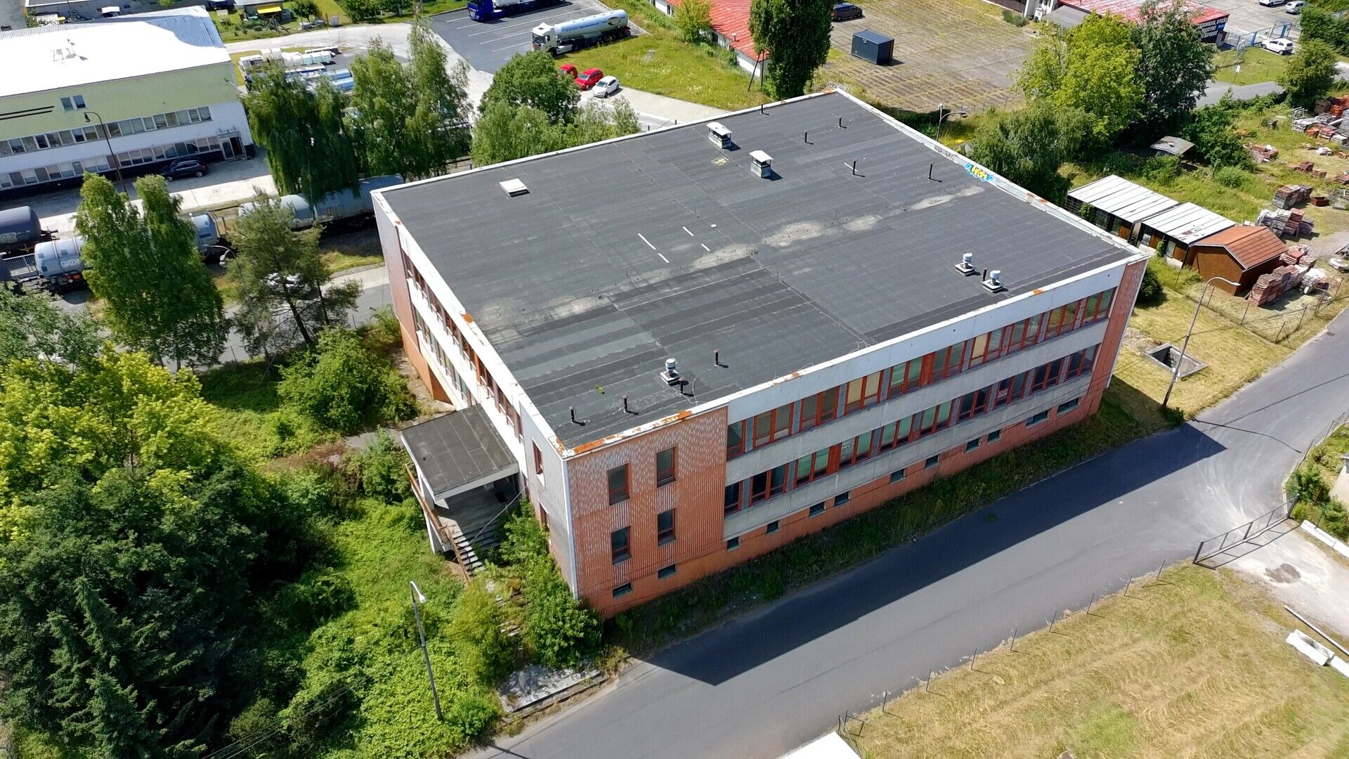 Třípodlažní průmyslový objekt o podlahové ploše cca 3.000 m2 s okolními pozemky