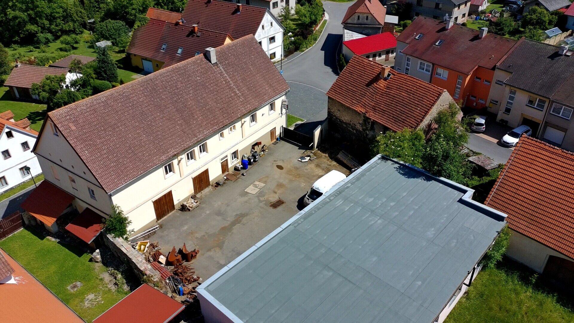 Areál pro podnikání zahrnující provozní budovu s byty, dílnami a sklady a budovu garáží-autodílen