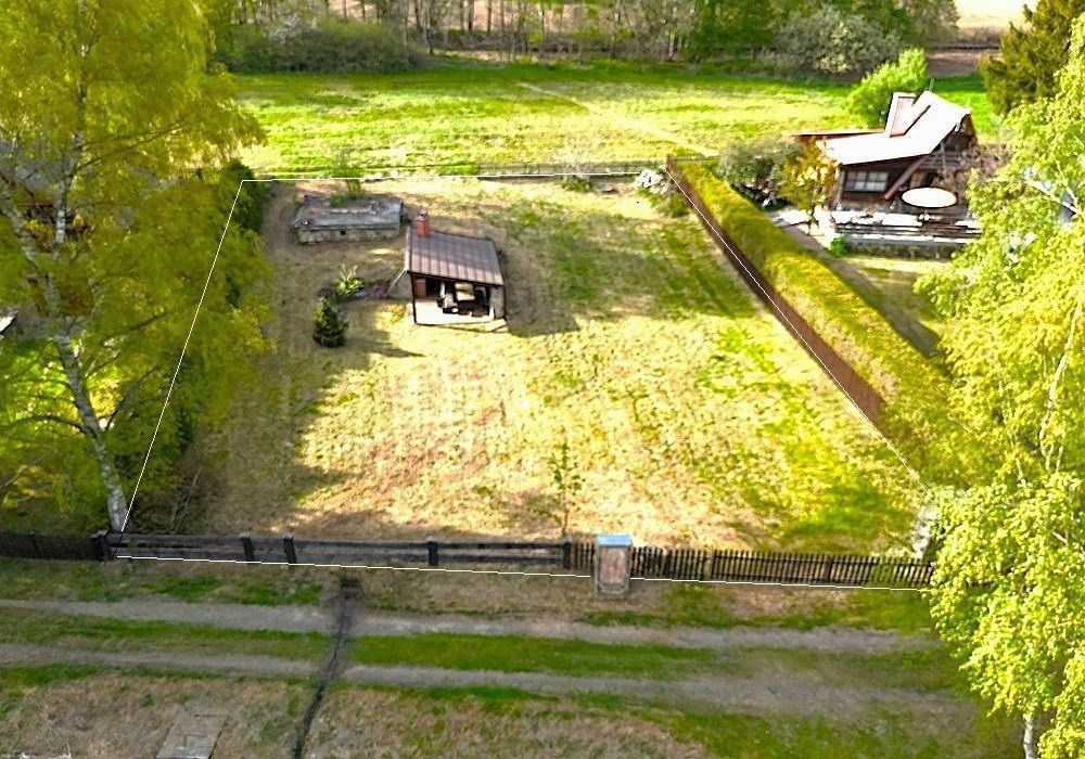 Zahrada s trávníkem a dřevěným altánem, obklopená plotem. Vhodné pro klidné bydlení, rekreaci nebo zahradničení.