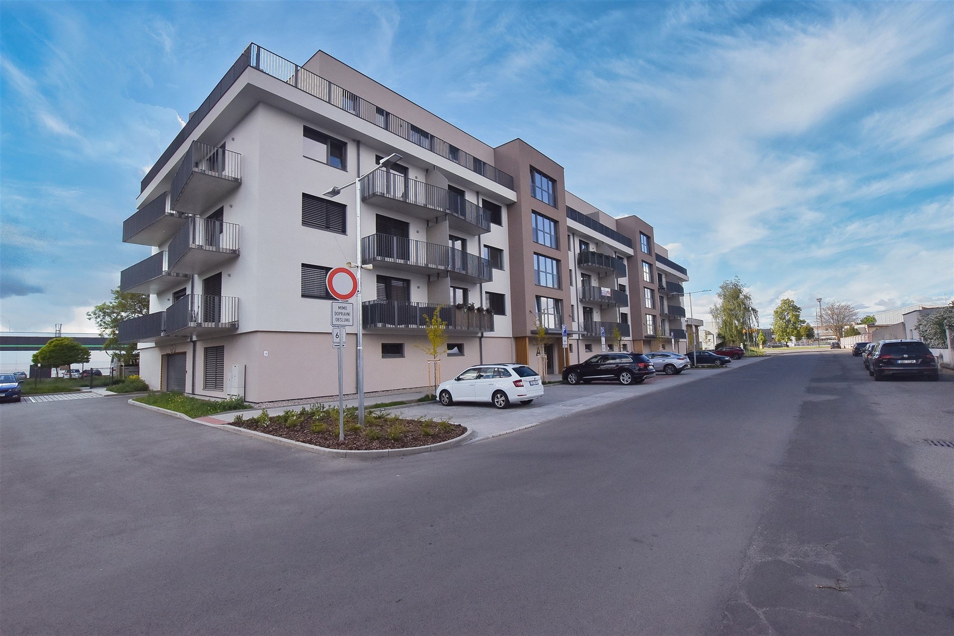 Moderní bytový dům s balkony, kvalitní povrchová úprava fasády, klidná lokalita s parkováním, ideální pro rodiny hledající nové bydlení