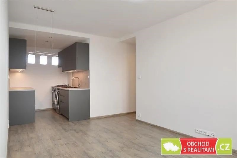 kuchyně s závěsné osvětlení, šedé skříňky, sporák, dřevěná podlaha, a deformace