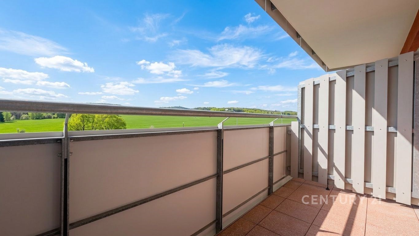 Balkon s výhledem na krajinu, dlažba, moderní zábradlí, světlý prostor, ideální pro relaxaci v přírodním prostředí.