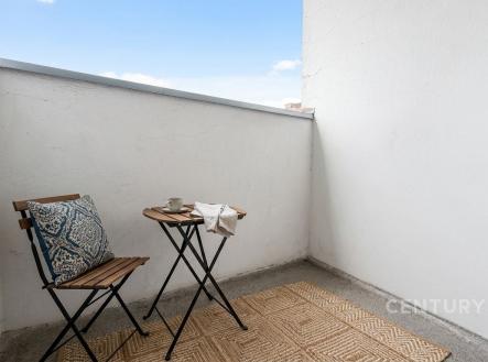Malý balkon s dlažbou, zahradním nábytkem a oslnivým výhledem. Skvělý prostor pro relaxaci a pití kávy.