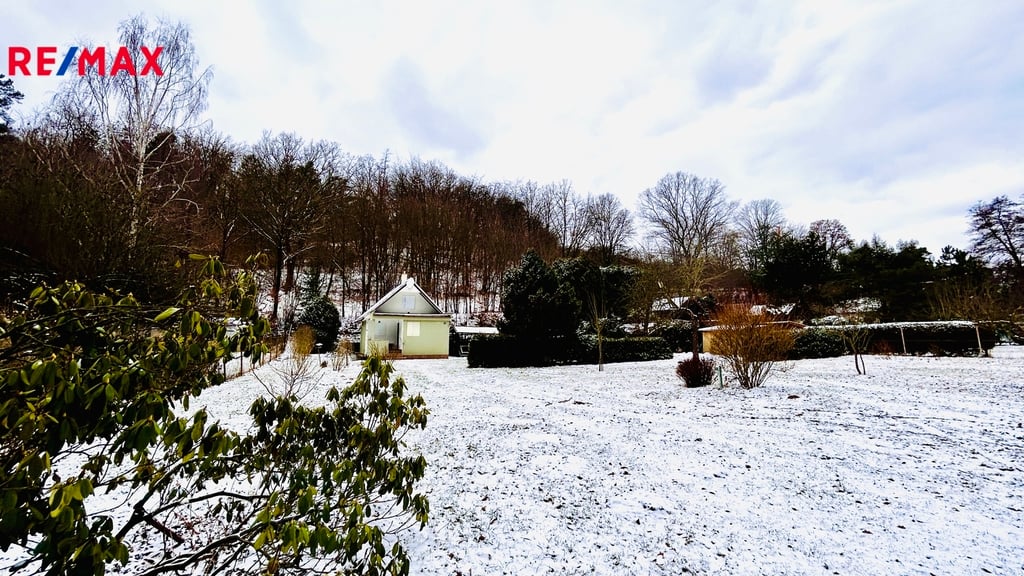 Pohled na chatu a zahradu od vjezdové brány