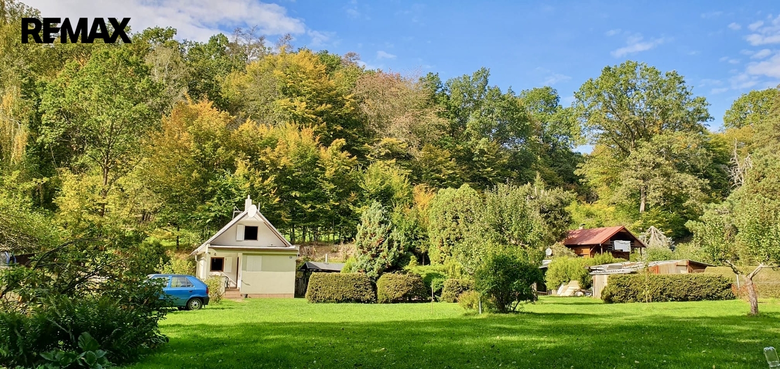 Pohled na chatu a zahradu od vjezdové brány