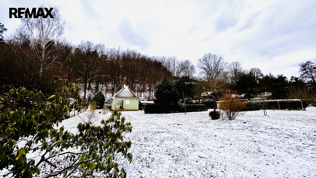 Pohled na chatu a zahradu od vjezdové brány