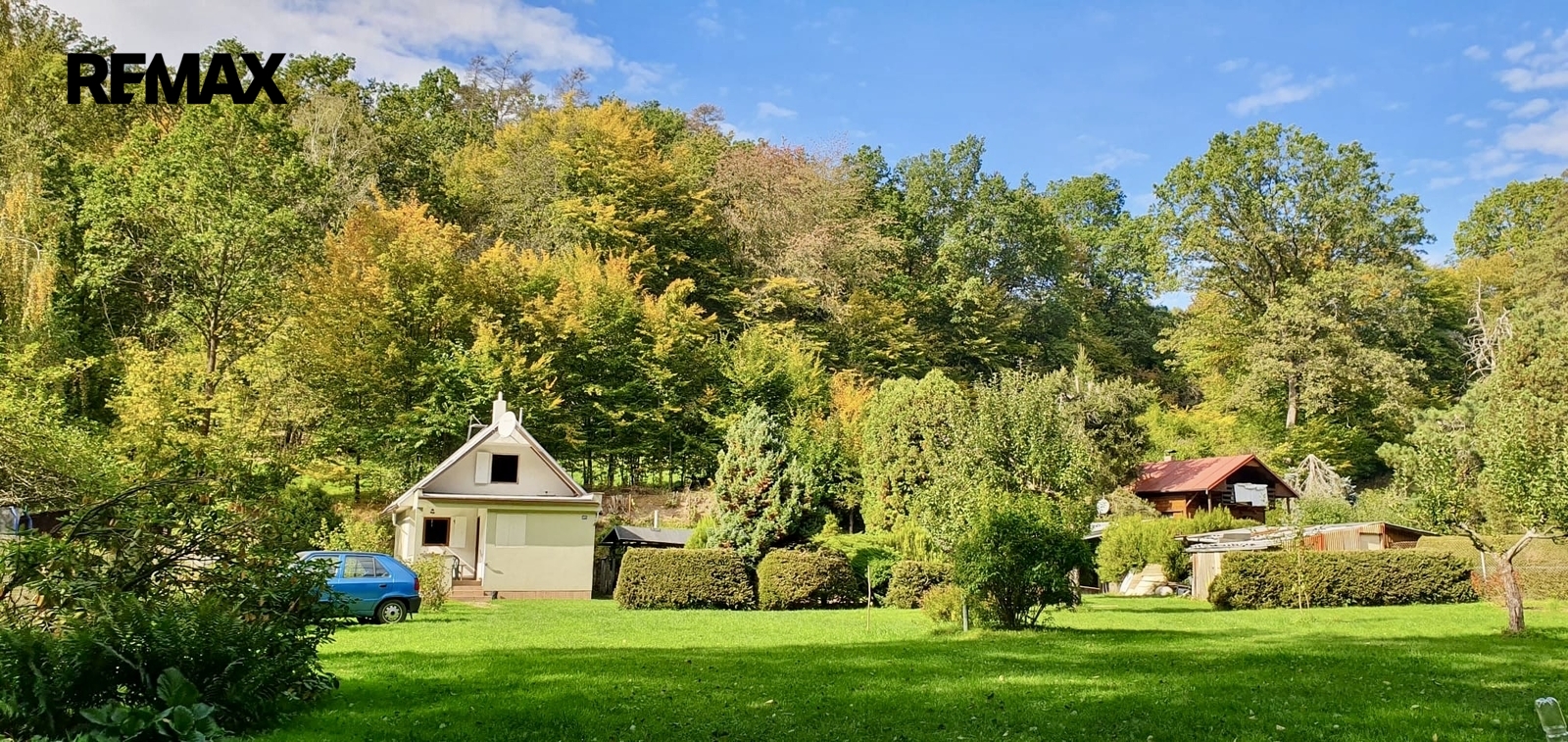 Pohled na chatu a zahradu od vjezdové brány