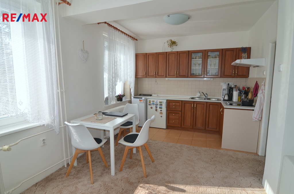 pohled na kuchyňský kout a jídelní stůl se třemi židlemi