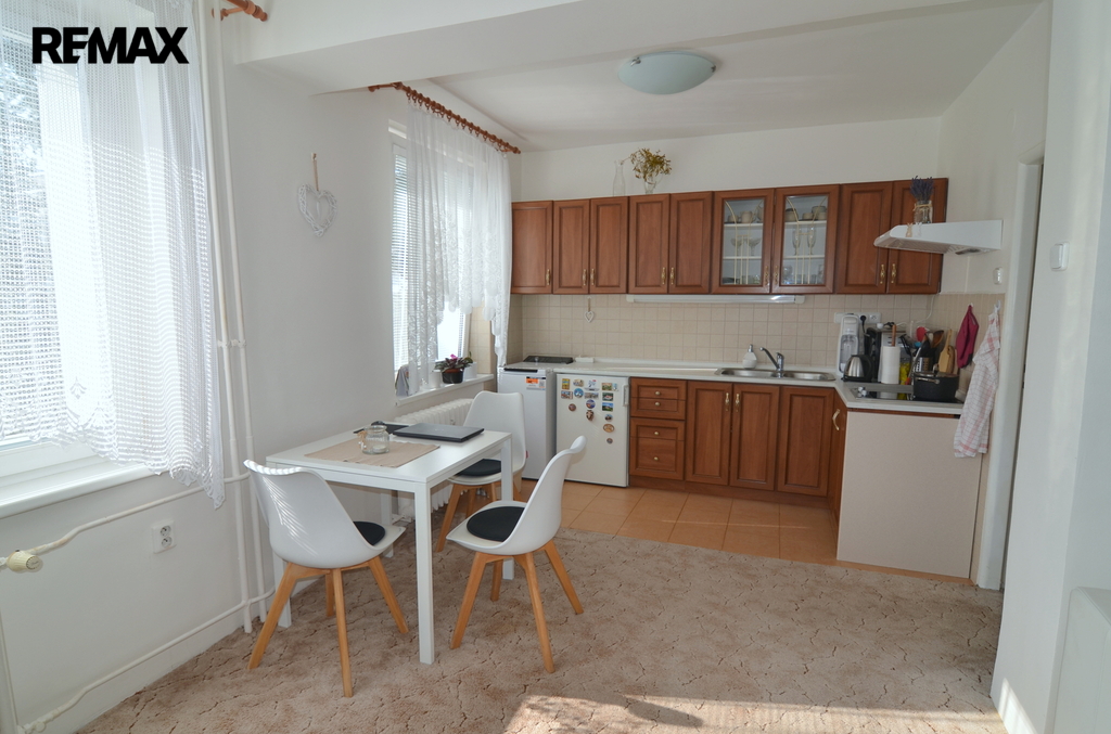 pohled na kuchyňský kout a jídelní stůl se třemi židlemi