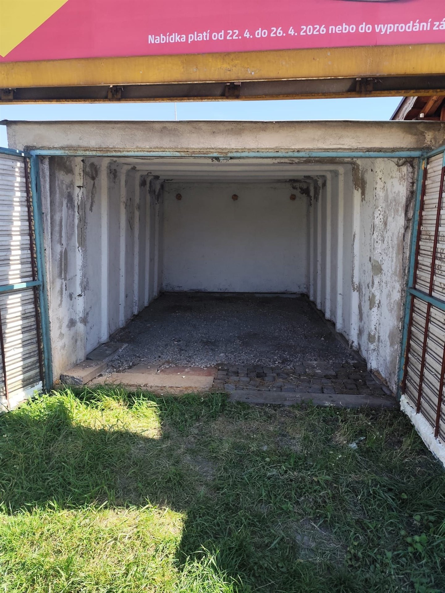 Garážový prostor se štěrkovou podlahou, nacházející se v bezpečné lokalitě.