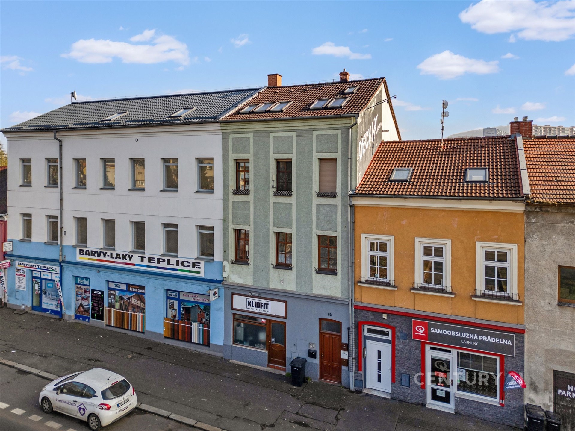 Řadový dům s výkladci, vícepatrový, smíšené fasádní barvy a střešní krytina z tašek, nacházející se ve městě