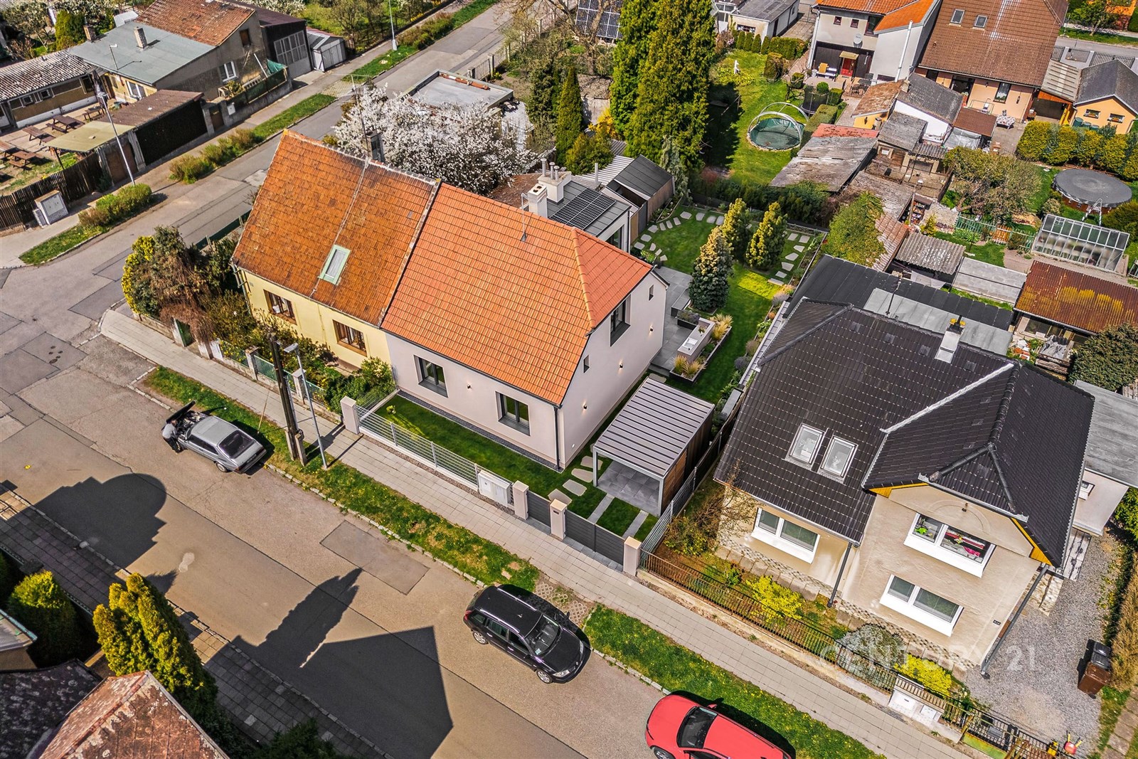Rodinný dům s červenou střešní krytinou, udržovaná zahrada, terasa a klidné prostředí.