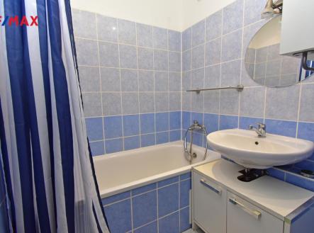 Koupelna s vanou a umyvadlem.