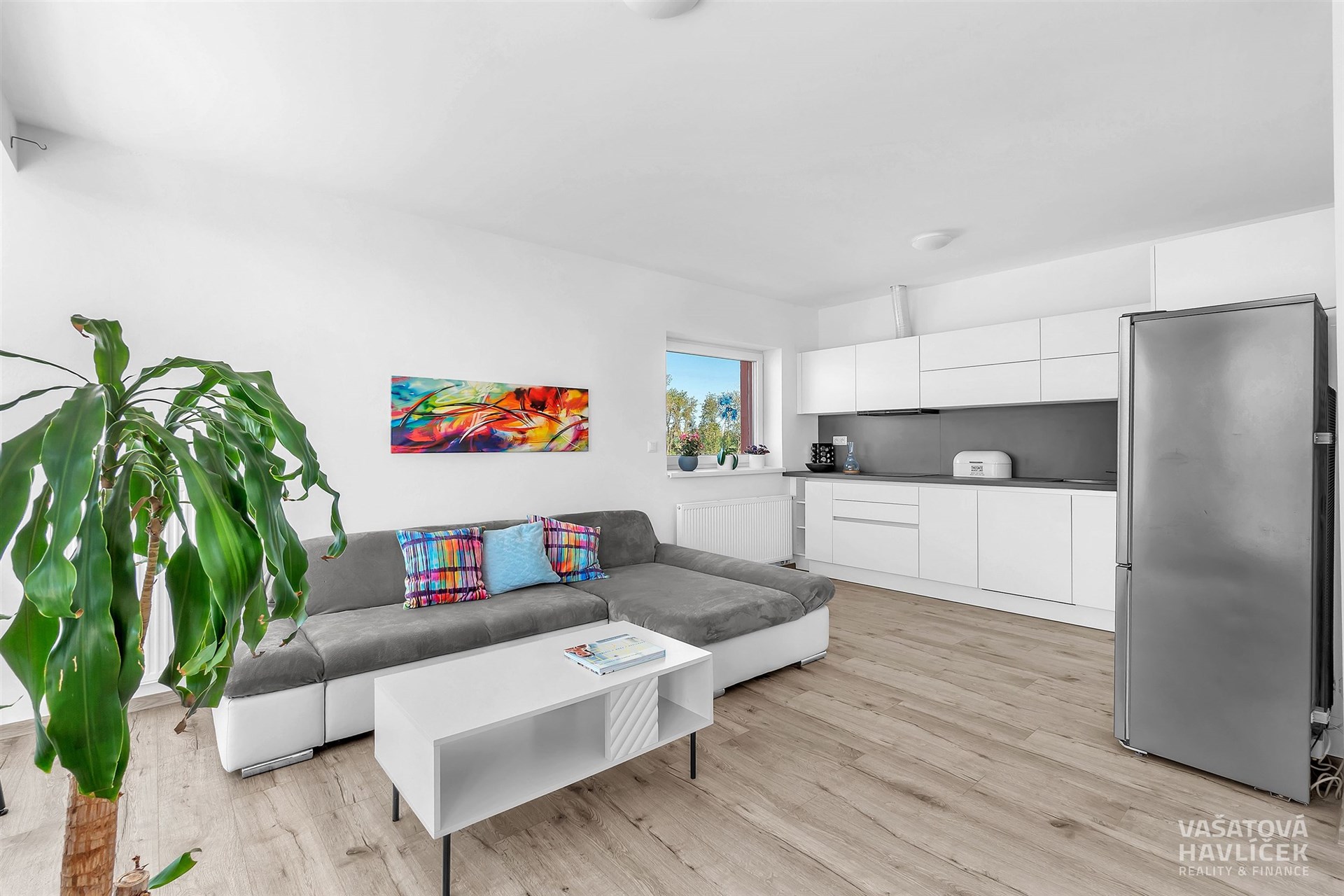 Světlý obývací pokoj s moderní kuchyní, parketová podlaha, vestavěné skříně, světlý design, velká okna poskytují dostatek přirozeného světla