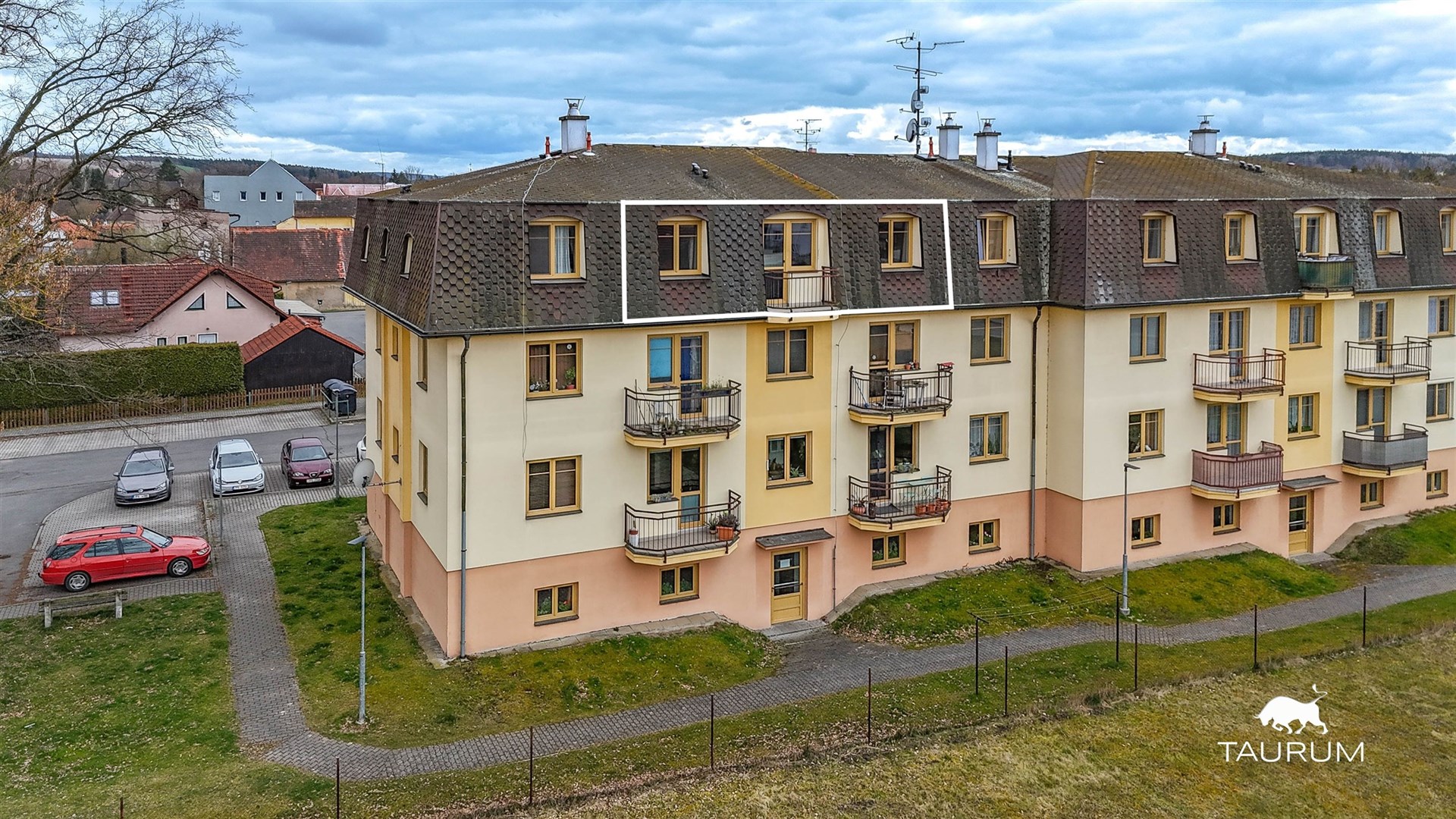 Vícepatrový bytový dům s balkony, zateplená fasáda, klidná lokalita, poblíž parkoviště, potenciál k modernizaci nebo rekonstrukci.