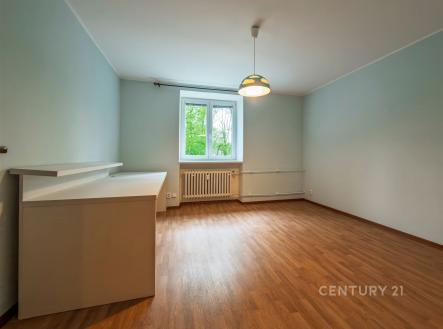 Světlý obývací pokoj s parketovou podlahou a velkým oknem, moderní styl a neutrální barvy, ideální pro přizpůsobení osobním preferencím