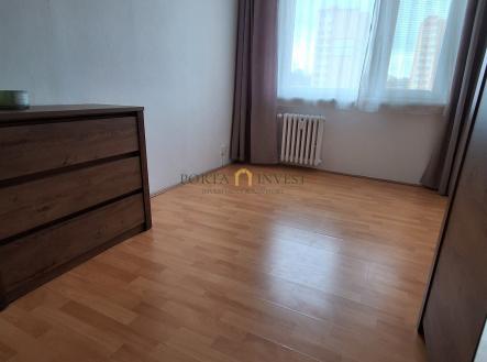 Prostorná ložnice s parketovou podlahou, velká okna poskytující dostatek světla, moderní závěsy pro stylový vzhled