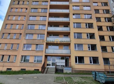 Šestipatrová bytová budova s balkonem, okenními rámy z hliníku a cihlovou fasádou, parkoviště před domem, v udržovaném stavu