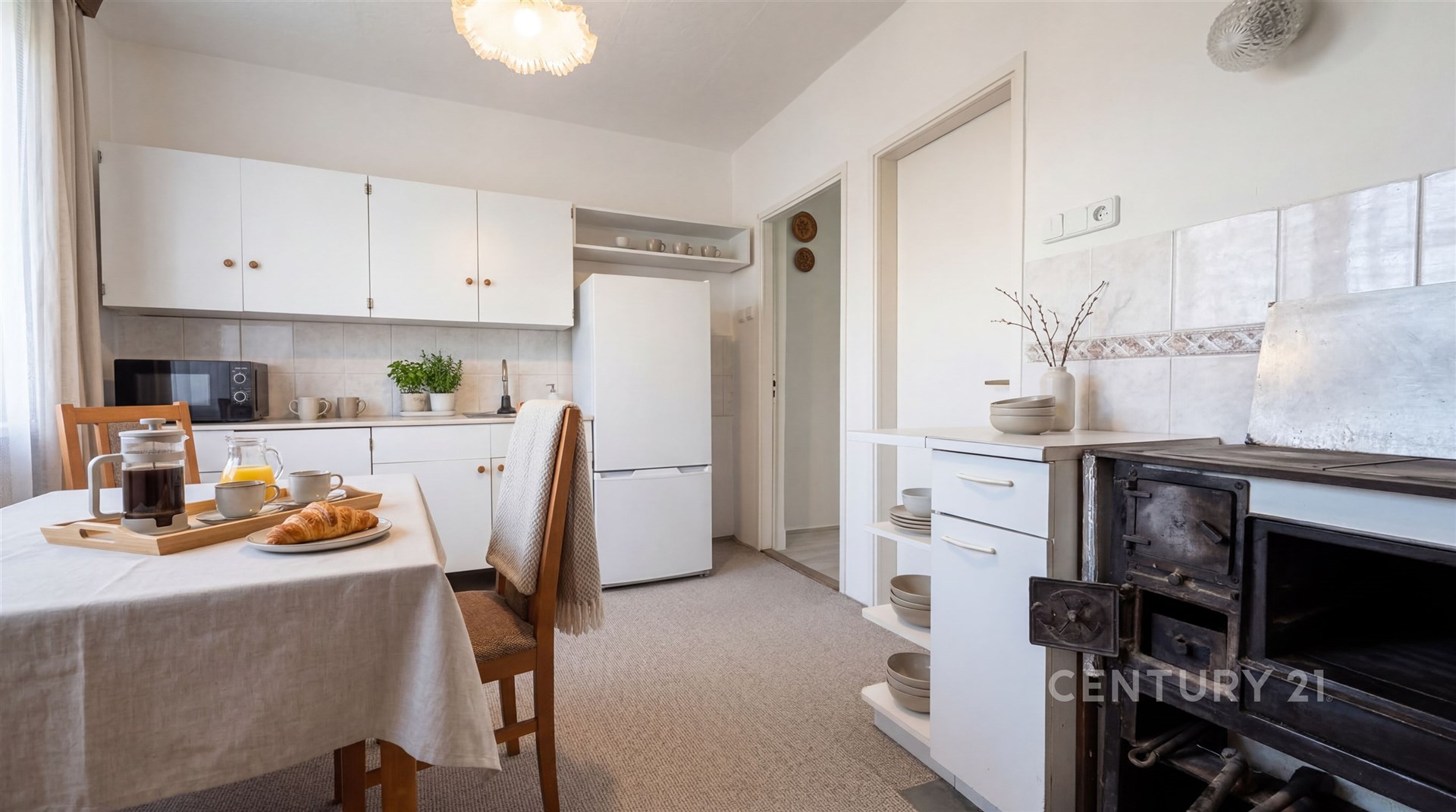 Kuchyň s retro kamny, světlý interiér, plovoucí podlaha, jídelní kout, vestavěné police, moderní spotřebiče