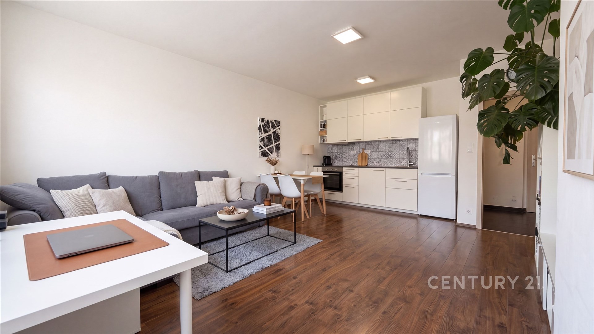Světlý obývací pokoj s moderní kuchyní, parketová podlaha, světlé stěny, vestavěné skříně, moderní vybavení, prostorný a elegantní interiér.
