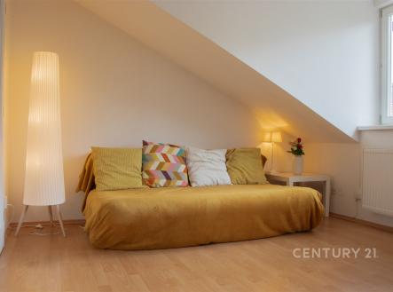 Podkrovní pokoj s parketovou podlahou, velká okna zajišťují světlé a útulné prostředí, minimalistický design s moderním vybavením.