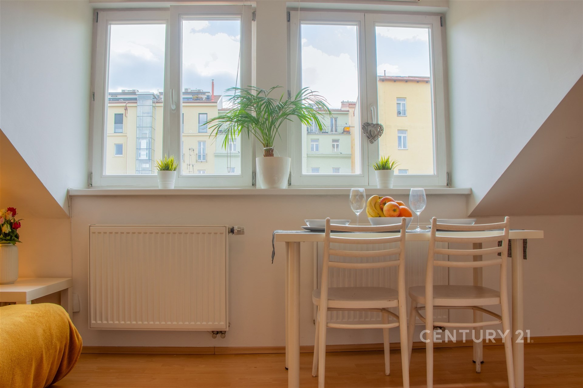 Světlá jídelna, parketová podlaha, velká okna, moderní interiér.