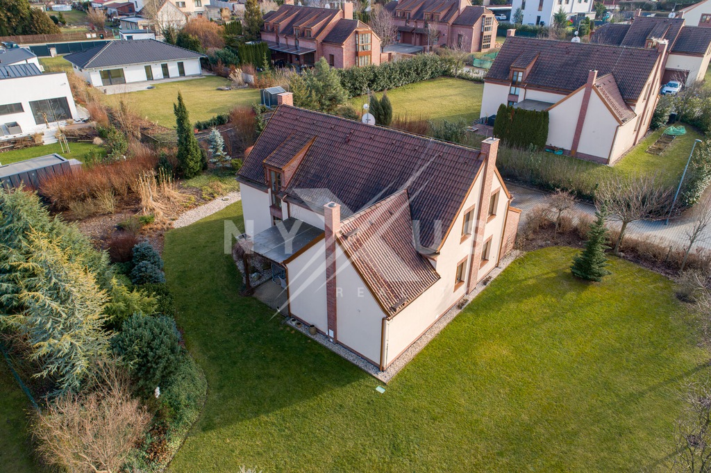 Okolní zástavbu tvoří moderní domy v upravených zahradách.