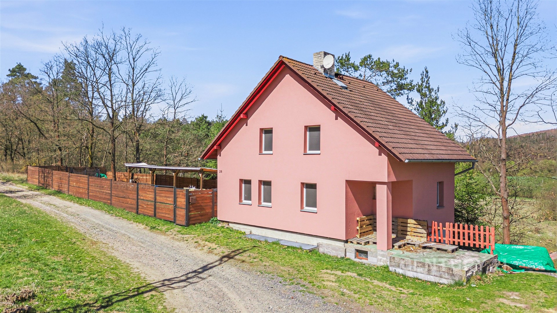Rodinný dům s novou fasádou, dřevěné oplocení, klidná lokalita v přírodě, udržovaná zahrada.