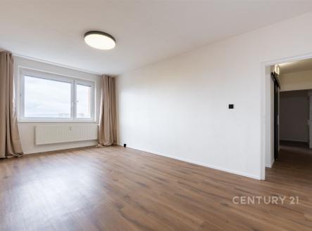 Světlý obývací pokoj, parketová podlaha, velká okna, moderní styl, neutrální barvy, prostorný interiér, vhodný pro rodiny.