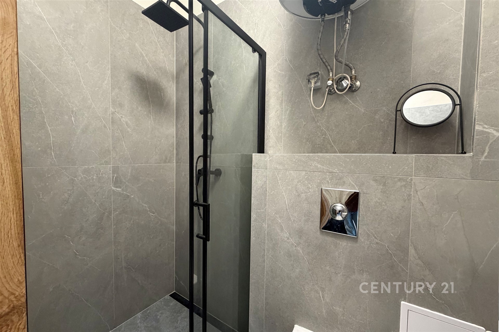 Moderní koupelna s keramickými obklady, sprchovým koutem a elegantními kovovými detaily.