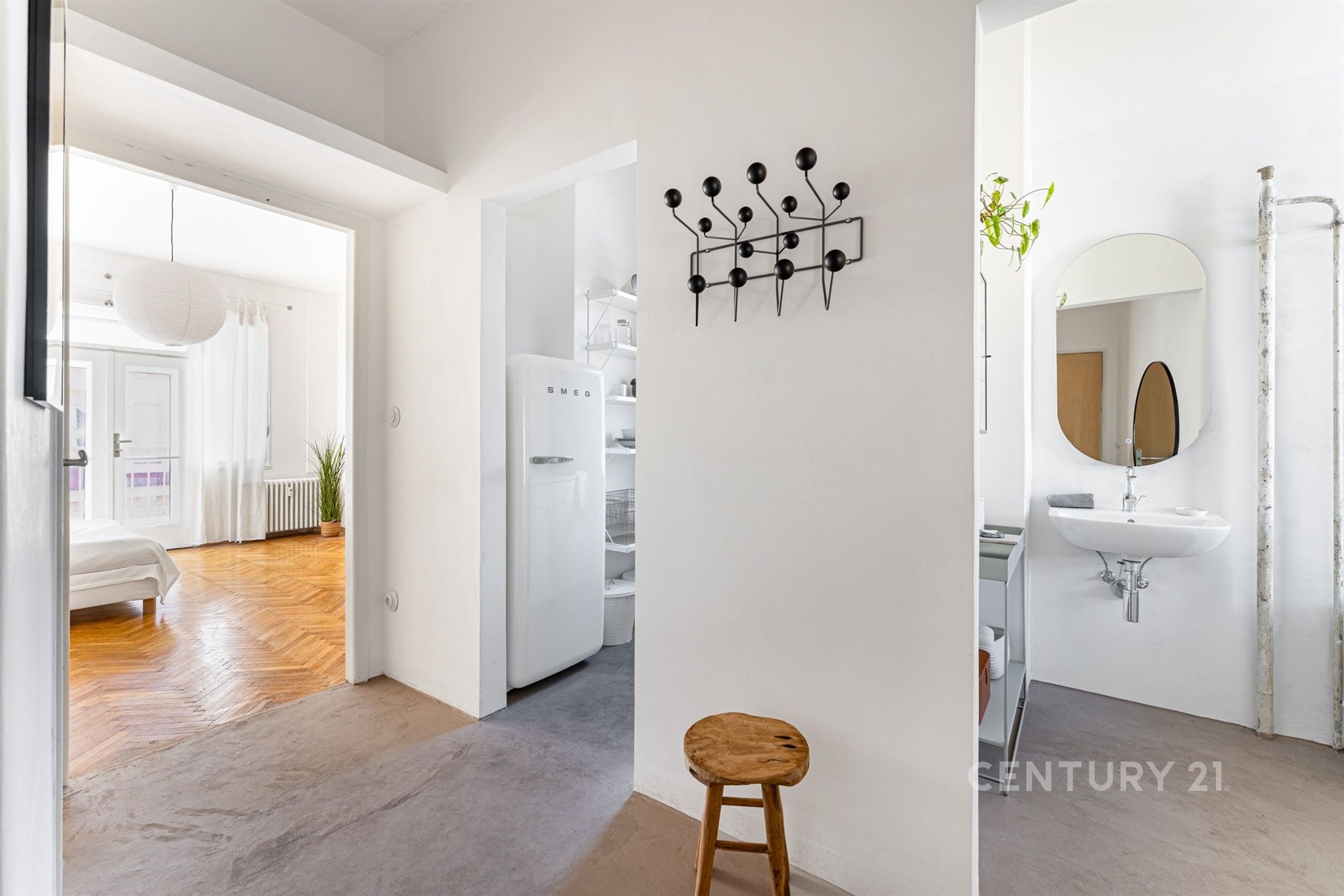 Vstupní hala s parketovou podlahou a moderními prvky, světlý prostor s vestavěnými skříněmi, přístup do koupelny a otevřený do obývací části.